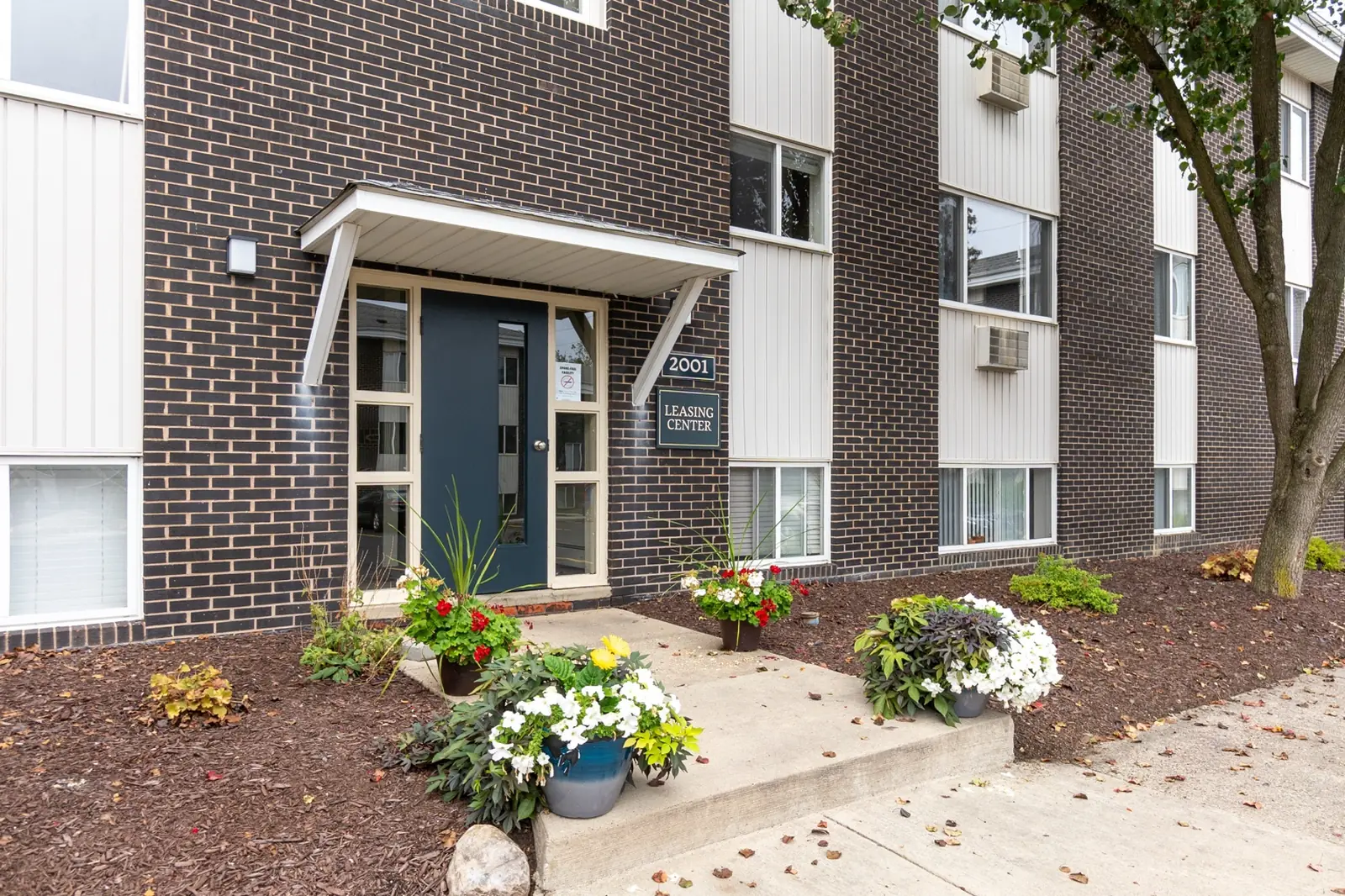 arborhillsapartments_2 Close-up of a residential building entrance at Arbor Hills Apartments with landscaped flower beds