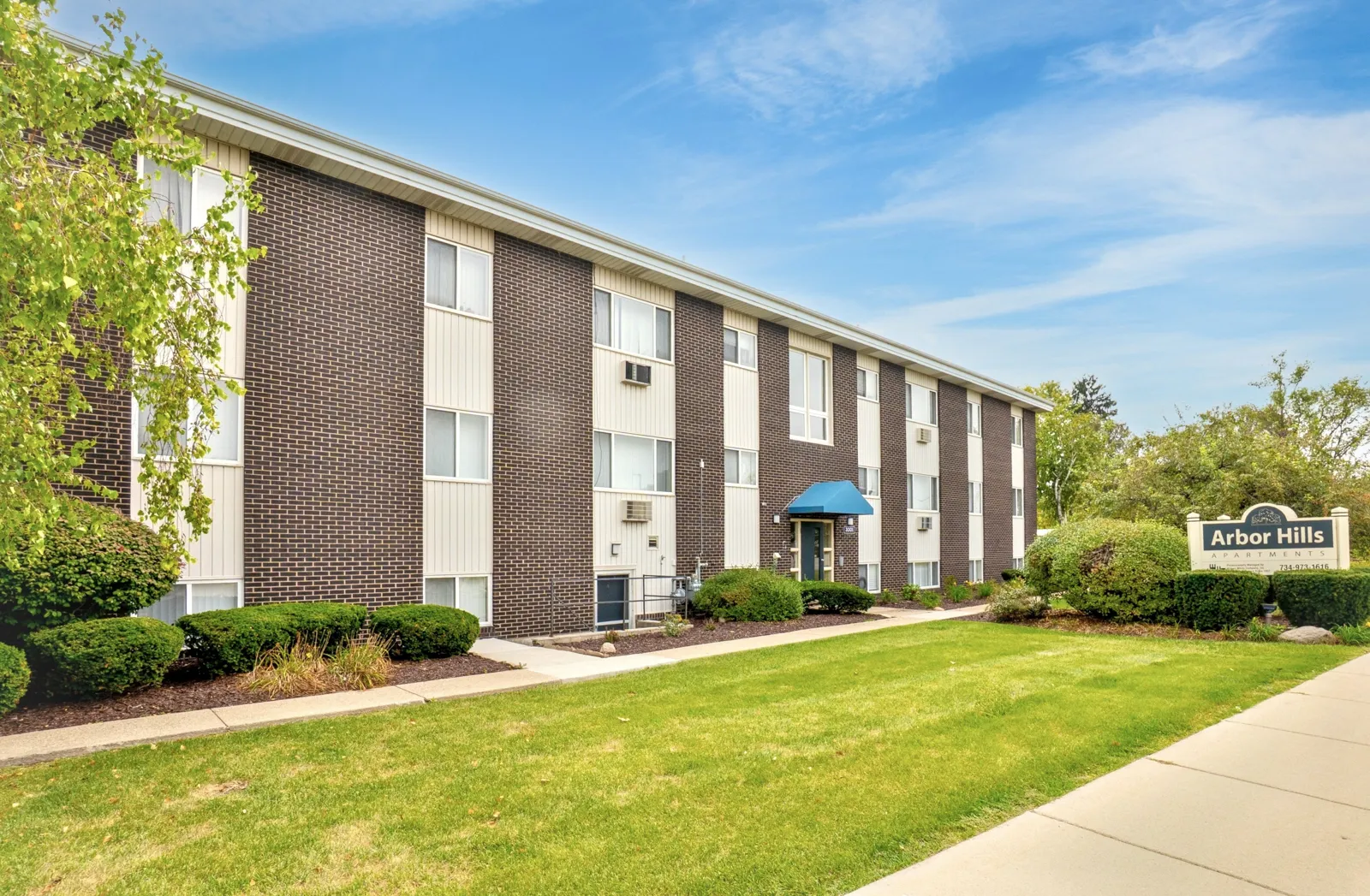 arborhillsapartments_7 Wide view of Arbor Hills Apartments buildings with green lawns and mature trees on a sunny day